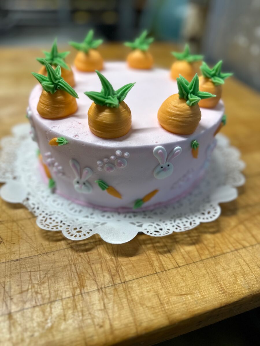 Pink Easter cake topped with piped buttercream carrots