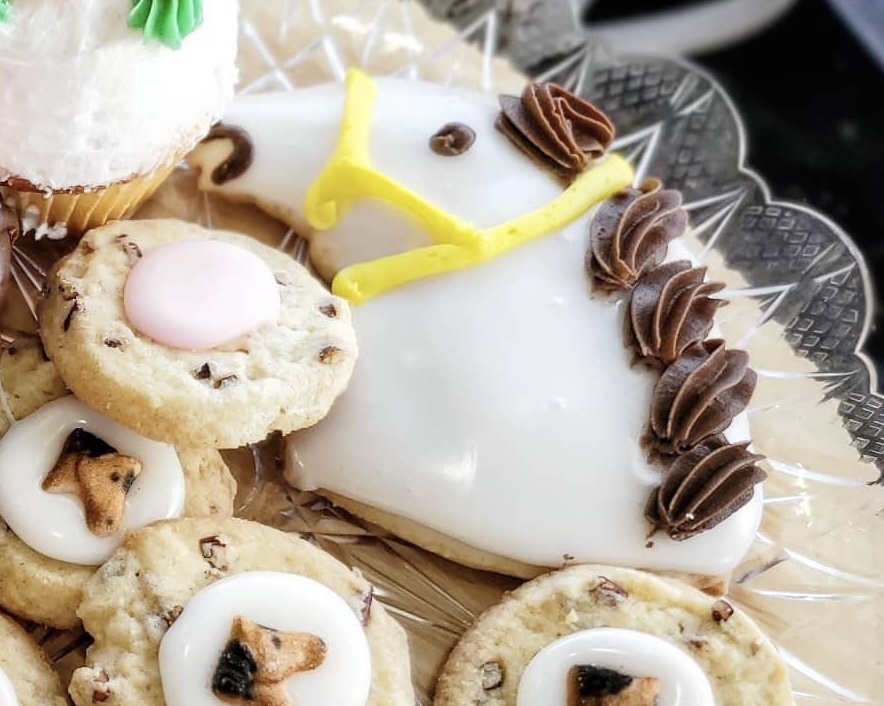 Iced Derby horse-head cookie on a plate of pecan cookies