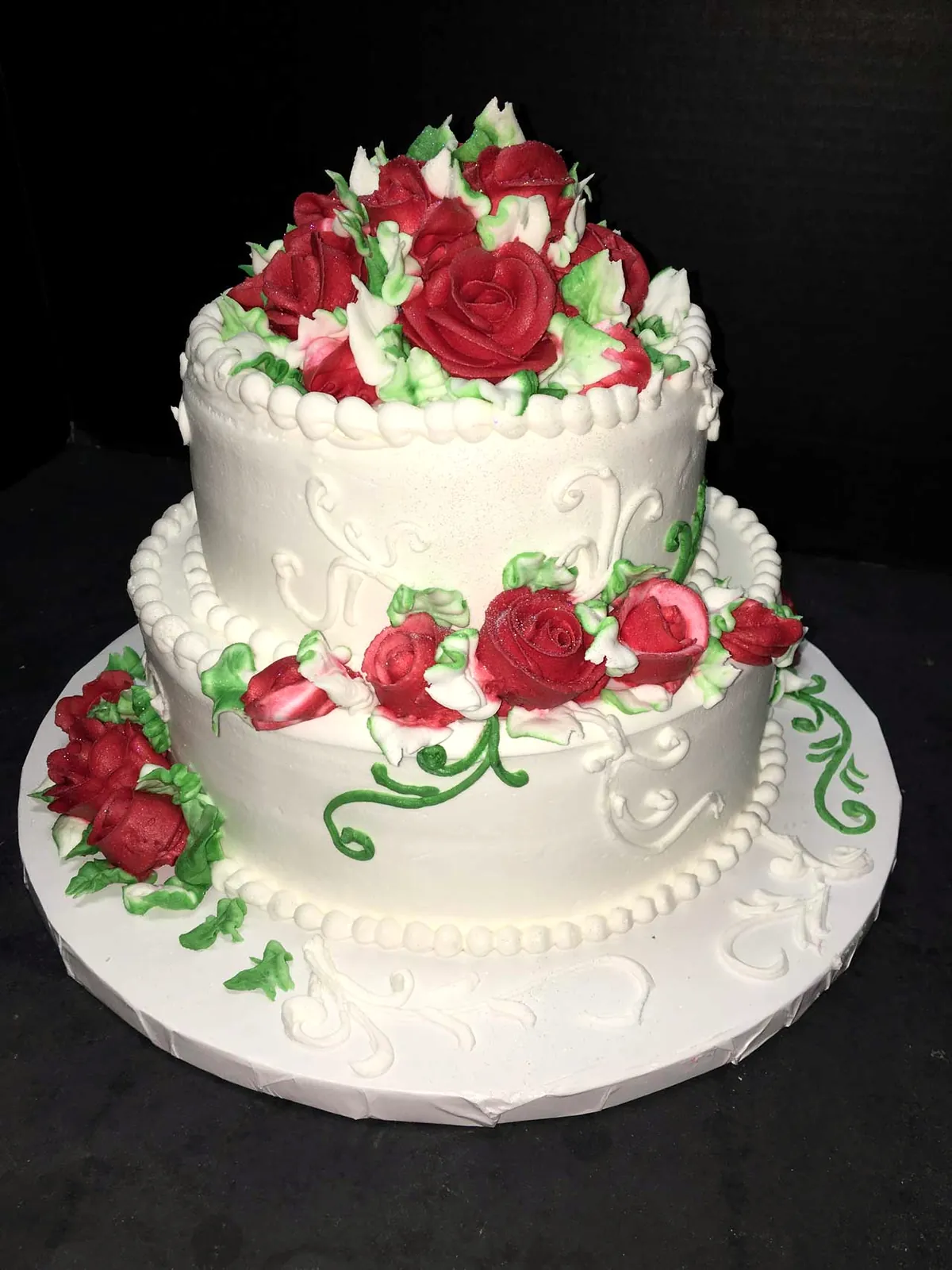 Two-tier white cake with red buttercream roses
